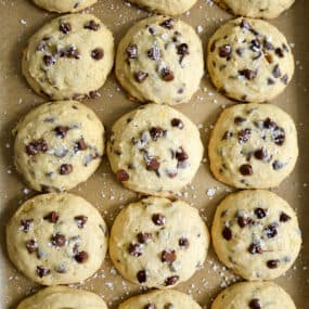 A top-down view of Banana Chocolate Chip Cookies on a parchment paper-lined baking sheet