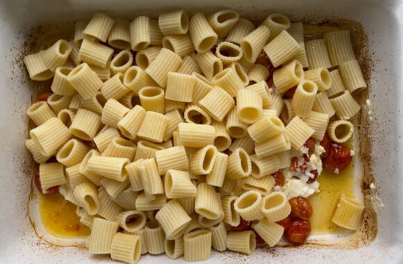 Pasta inside a baking dish with baked feta