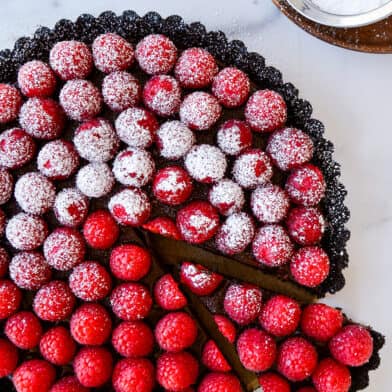 Top-down view of Easy No-Bake Chocolate Tart with Raspberries half dusted with powdered sugar