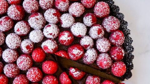 Top-down view of Easy No-Bake Chocolate Tart with Raspberries half dusted with powdered sugar