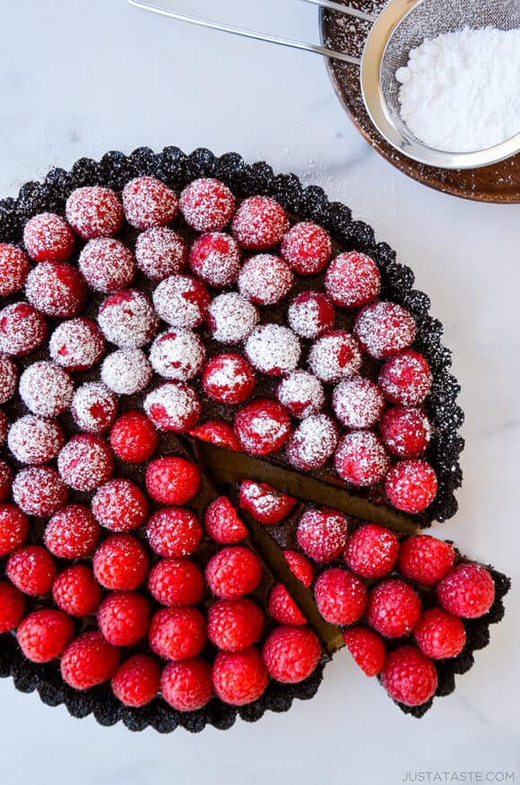 Top-down view of Easy No-Bake Chocolate Tart with Raspberries half dusted with powdered sugar