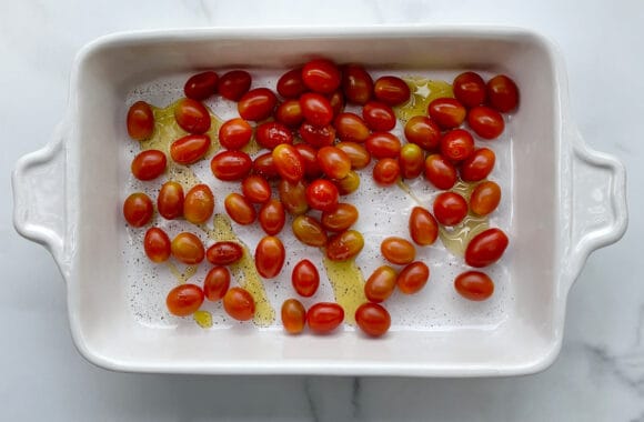 Cherry tomatoes, olive oil and pepper in a baking dish