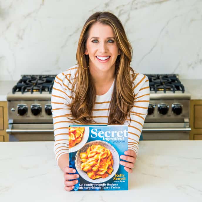 Kelly Senyei holding a copy of The Secret Ingredient Cookbook