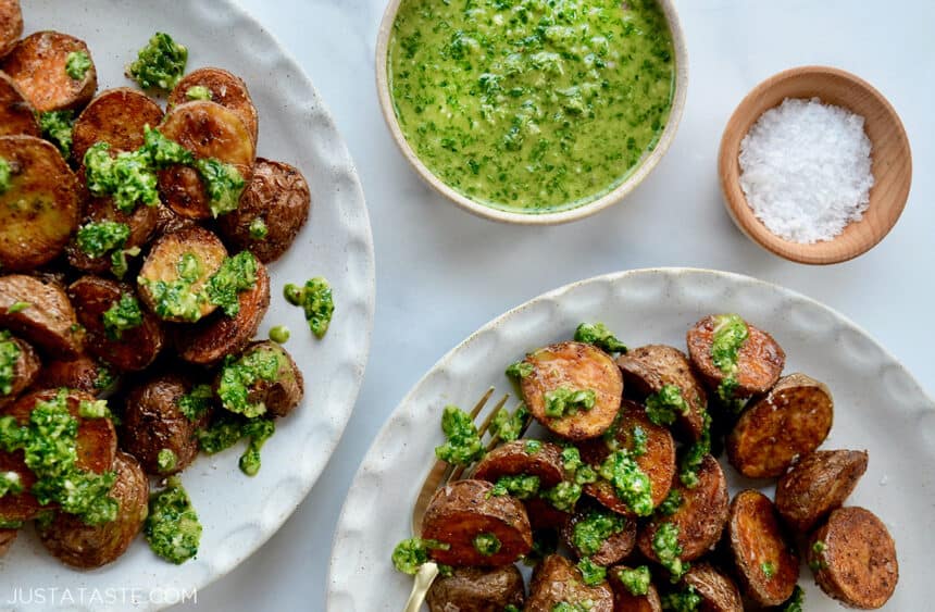 White plates topped with roasted potatoes and homemade chimichurri sauce