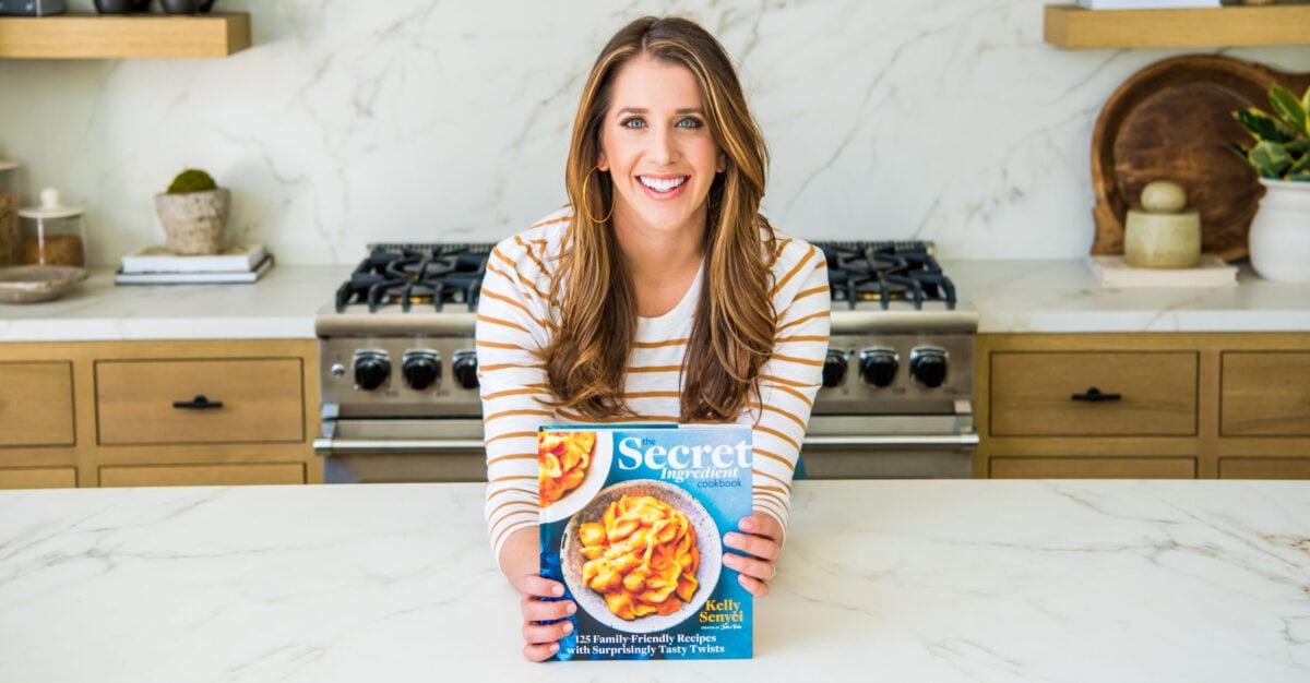 Kelly Senyei holding a copy of The Secret Ingredient Cookbook