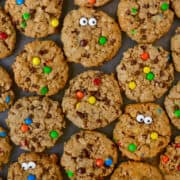 Top-down view of monster cookies studded with mini M&Ms and candy eyes