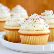 Vanilla bean cupcakes topped with vanilla bean buttercream frosting and rainbow sprinkles