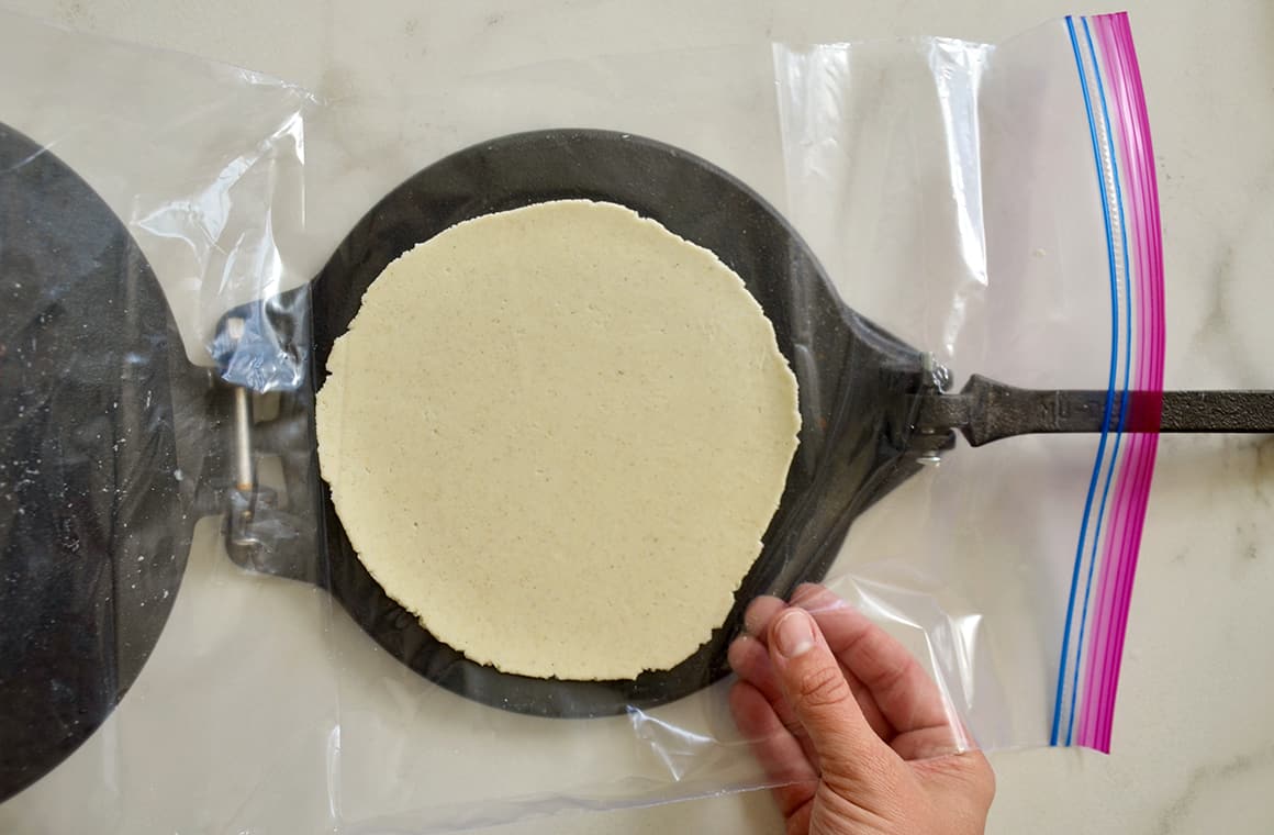 A corn tortilla press with dough inside