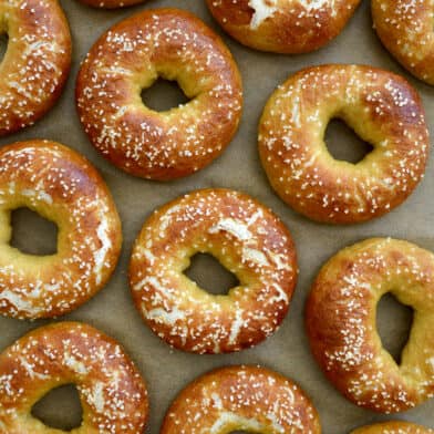 A top-down view of Easy Soft Pretzel Bagels on tan parchment paper