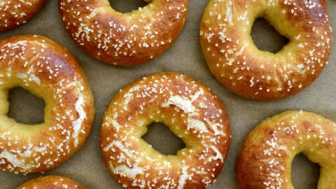 A top-down view of Easy Soft Pretzel Bagels on tan parchment paper