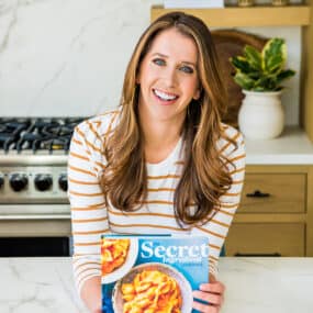 Kelly Senyei holding a copy of The Secret Ingredient Cookbook