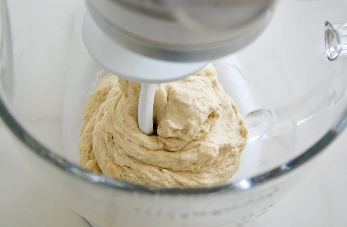 Soft pretzel dough in a clear stand mixing bowl