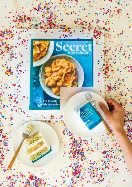 The Secret Ingredient Cookbook as a cake surrounded by rainbow sprinkles