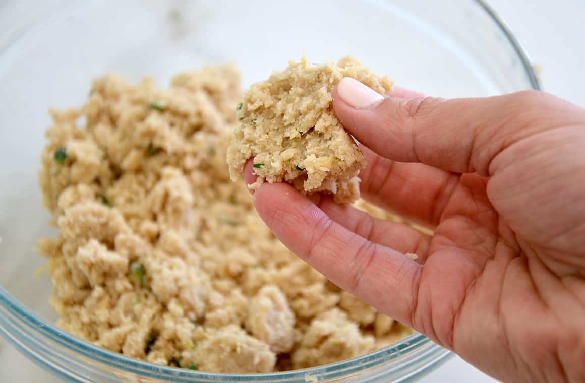 A hand pinching together crumble topping