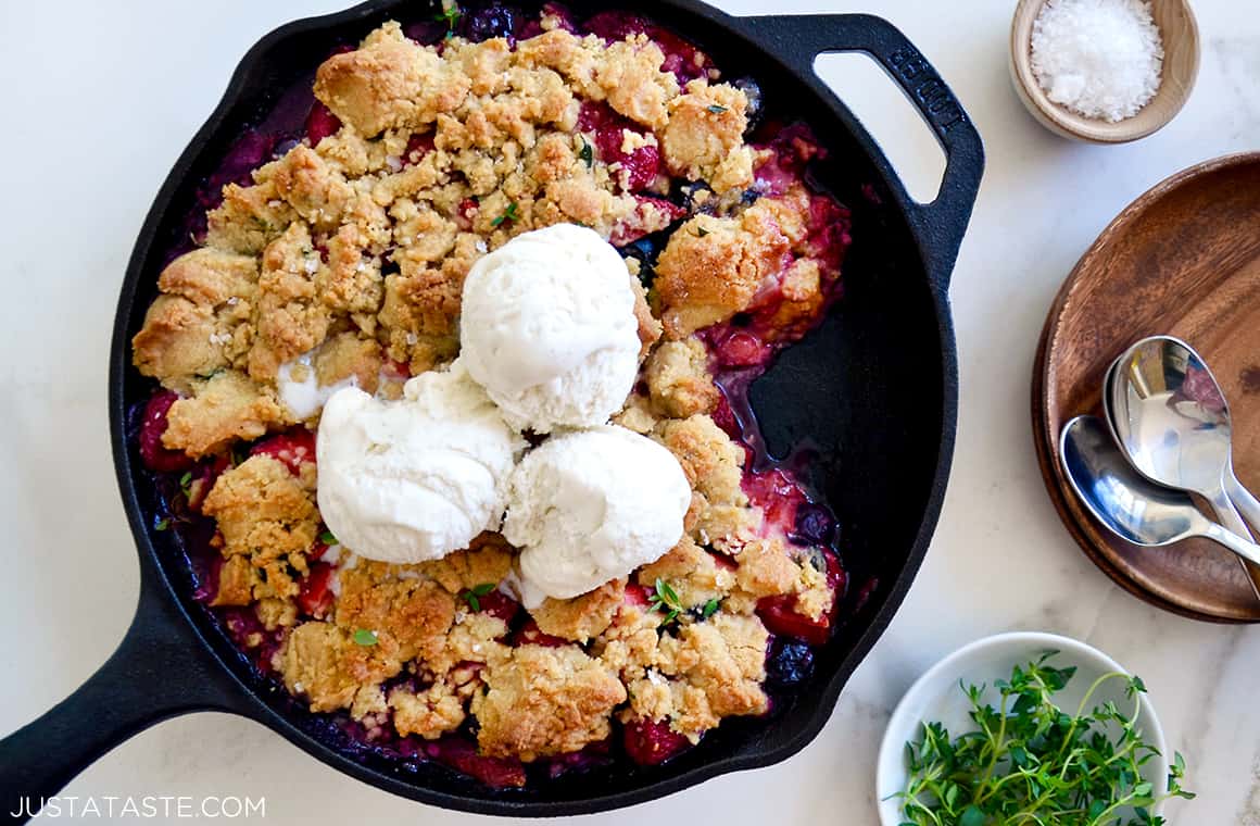 A cast-iron skillet containing mix-and-match fruit crumble topped with ice cream