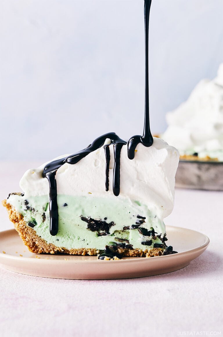 Mint chocolate chip ice cream pie with a waffle cone crust topped with a thick layer of whipped cream and drizzled with chocolate syrup.