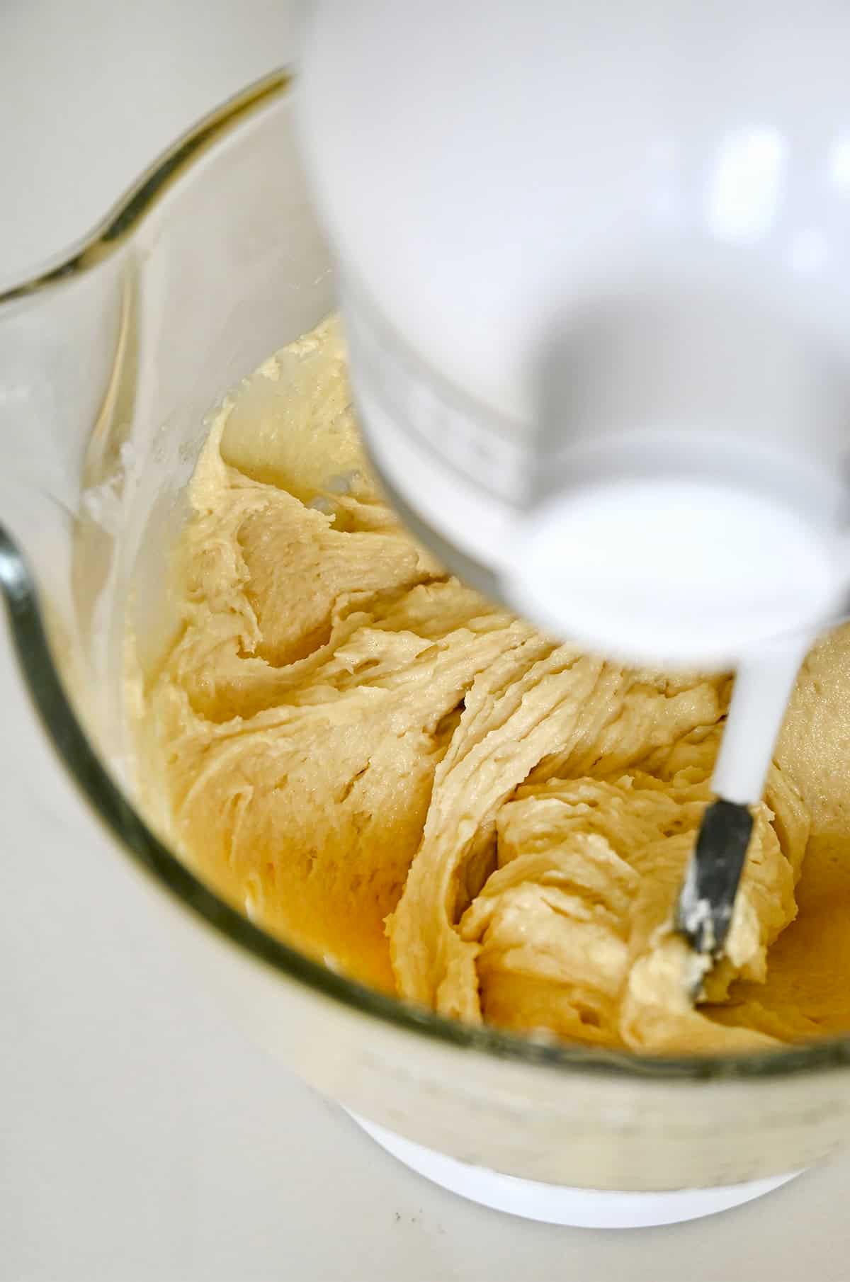 Muffin batter in a stand mixer bowl with the paddle attachment.