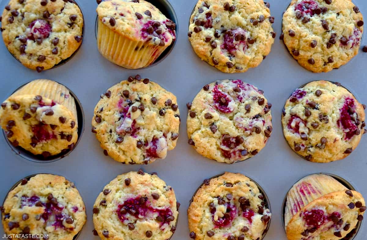 Fresh-baked chocolate chip raspberry muffins in a muffin tin.