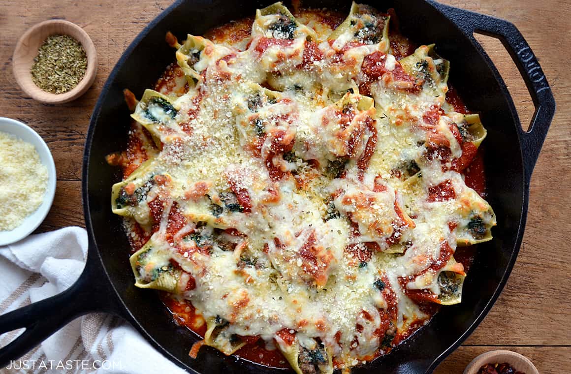 A cast-iron skillet containing stuffed shells with meat and ricotta