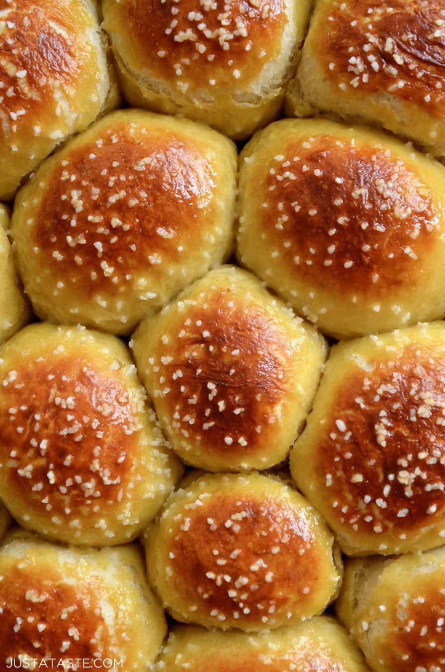 A close-up of baked pretzel rolls topped with salt