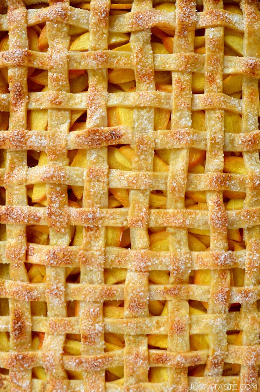 A close-up of lattice pie crust with peach filling