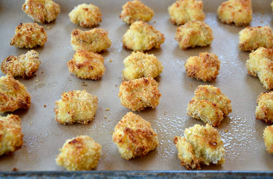 Homemade Panko chicken nuggets lined up on a baking sheet