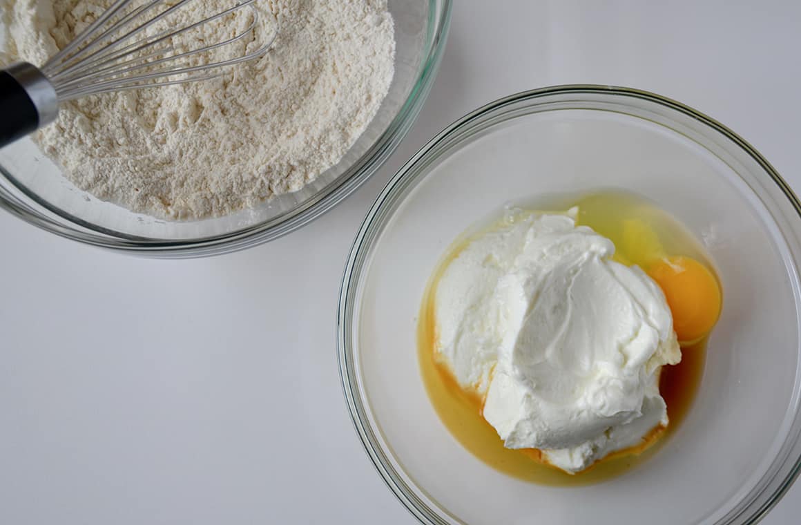 Two glass bowls containing wet and dry ingredients for pancakes