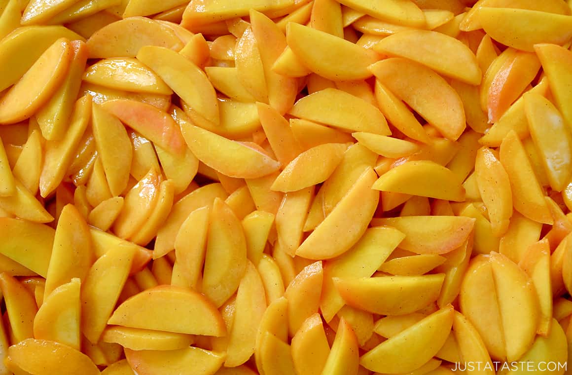 A close-up of sliced peaches tossed with brown sugar