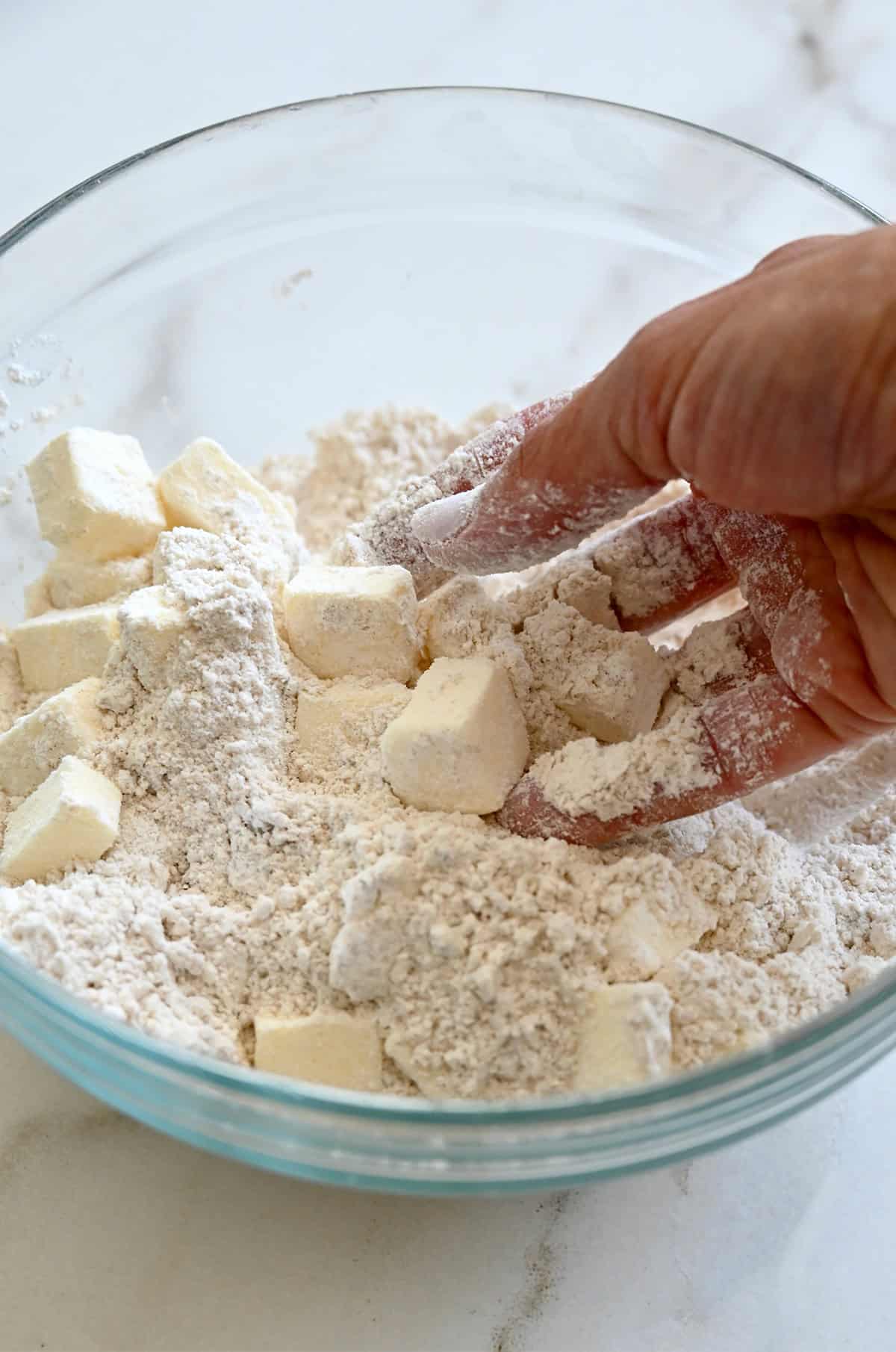 Working cubes of butter into flour and brown sugar to make a shortbread dough.