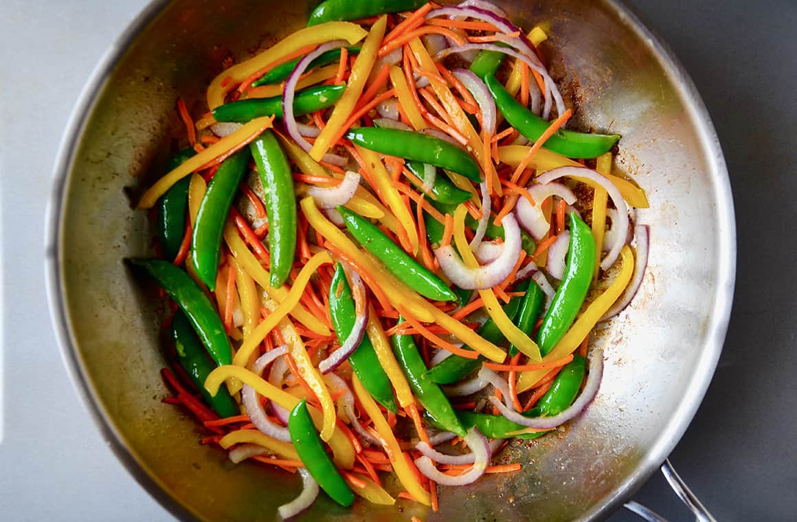 Vegetables in a stainless steel sauté pan