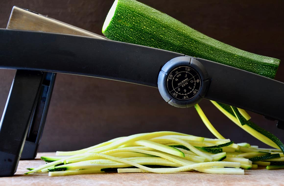 A mandoline with a zucchini on top