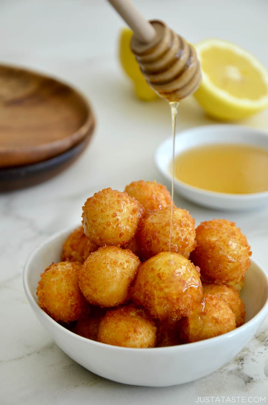 A bowl of fried goat cheese balls with lemon in the background