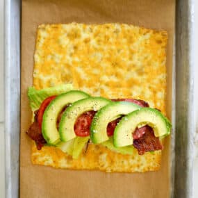 A top-down view of melted cheese sandwich wrap filled with turkey, bacon, avocado, lettuce and tomato