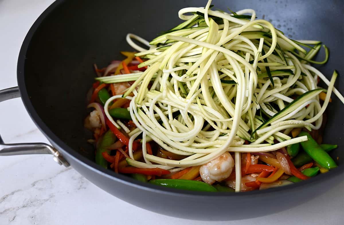 Shrimp, stir-fried veggies and zucchini noodles in a wok.