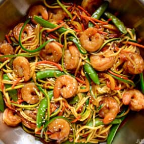 A top-down view of stir-fry with zucchini noodles and shrimp