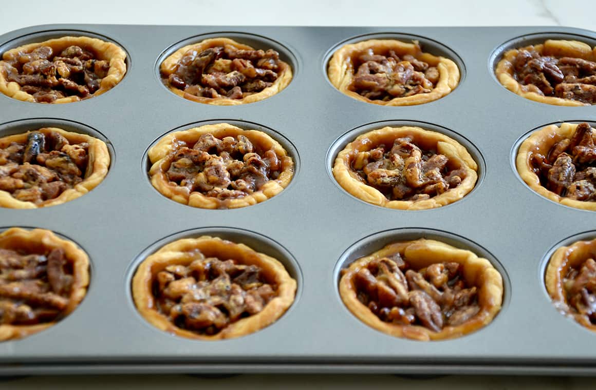 Freshly baked golden brown individual pecan pies