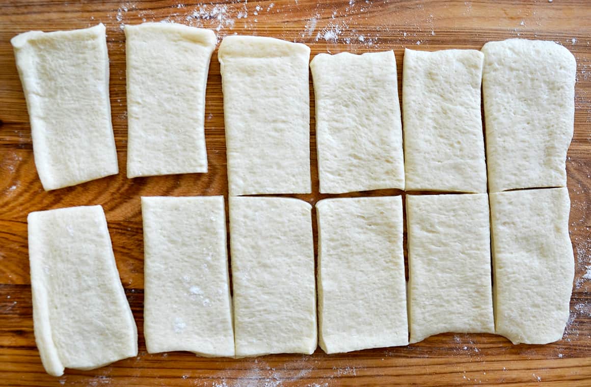 Sliced pizza dough on a wooden surface