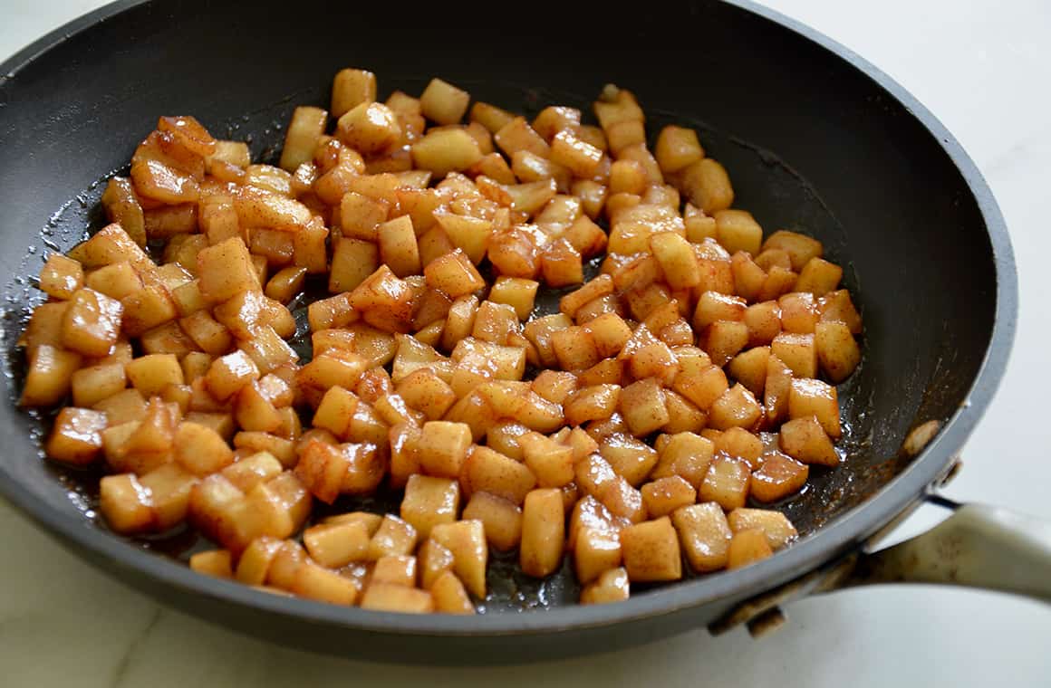 A large skillet containing diced sautéed apples
