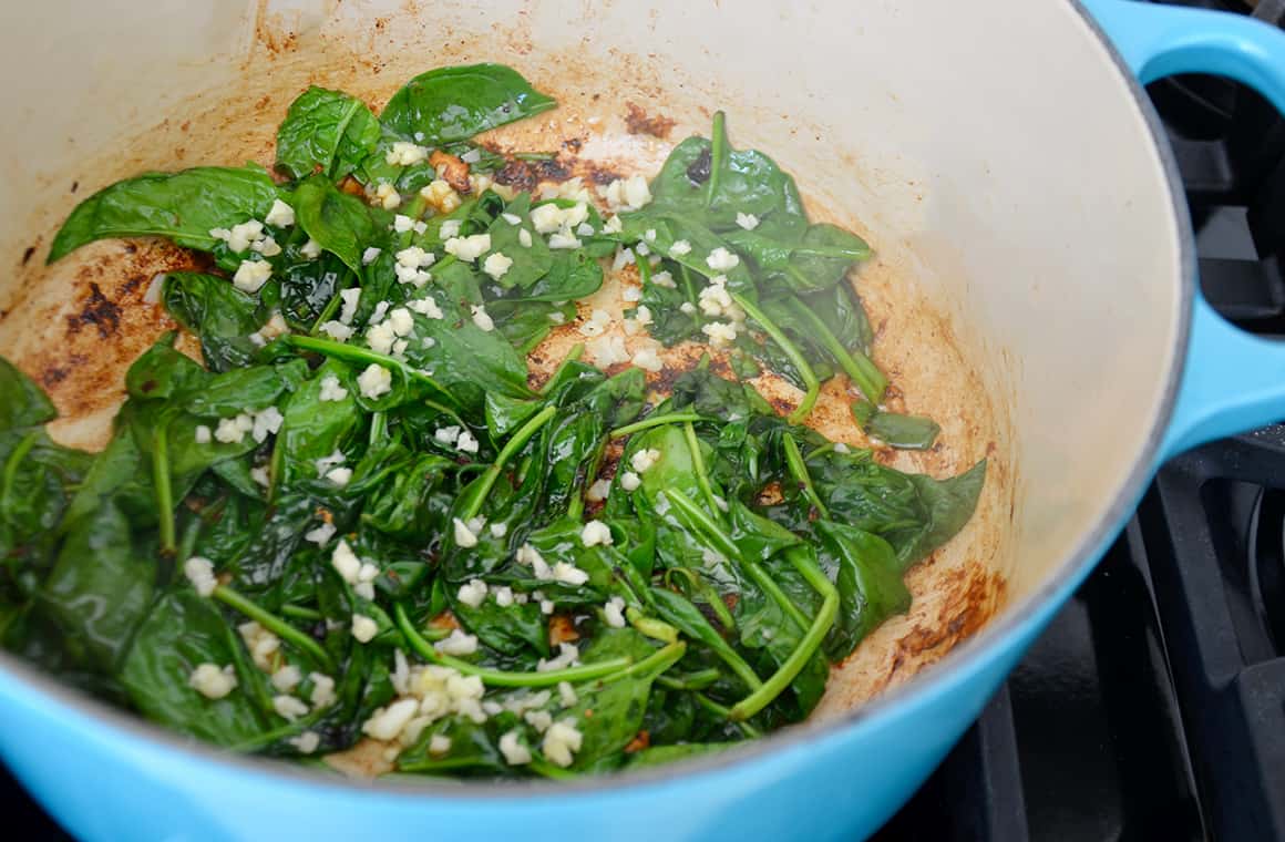 Spinach and garlic in a large blue pot