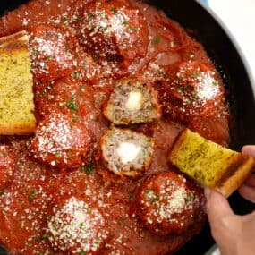 A skillet containing Cheese-Stuffed Meatballs with Garlic Bread Dippers