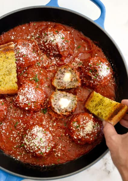 A skillet containing Cheese-Stuffed Meatballs with Garlic Bread Dippers