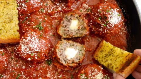 A skillet containing Cheese-Stuffed Meatballs with Garlic Bread Dippers