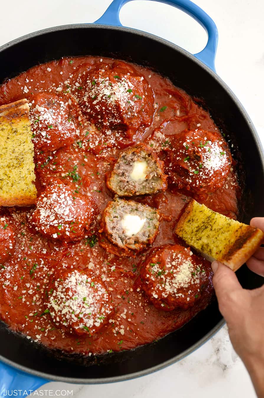 A skillet containing Cheese-Stuffed Meatballs with Garlic Bread Dippers