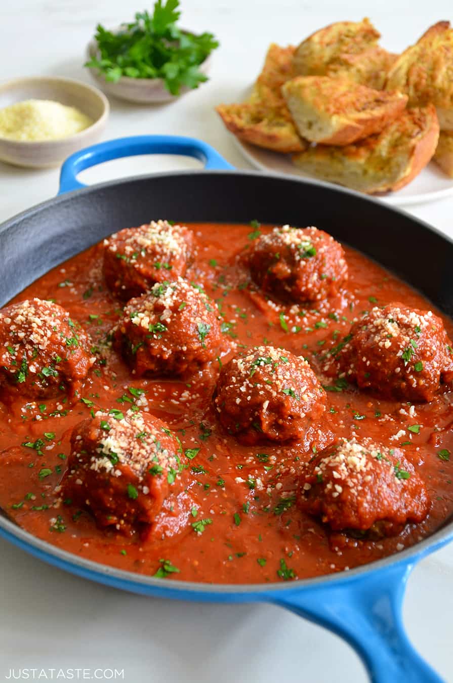 A skillet containing marinara sauce and Cheese-Stuffed Meatballs 