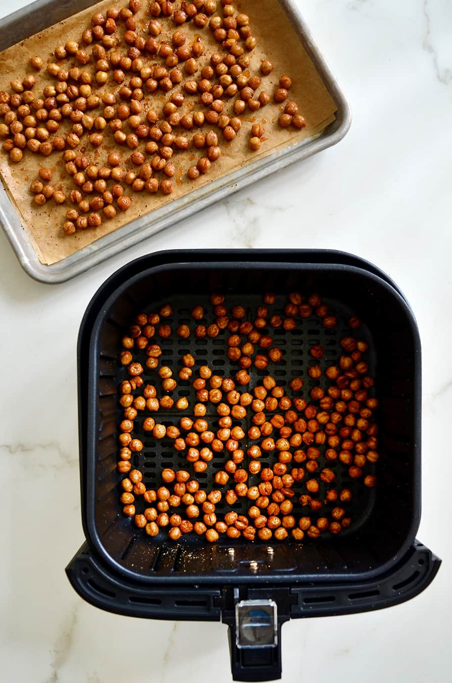 A baking sheet of roasted chickpeas and an air fryer basket