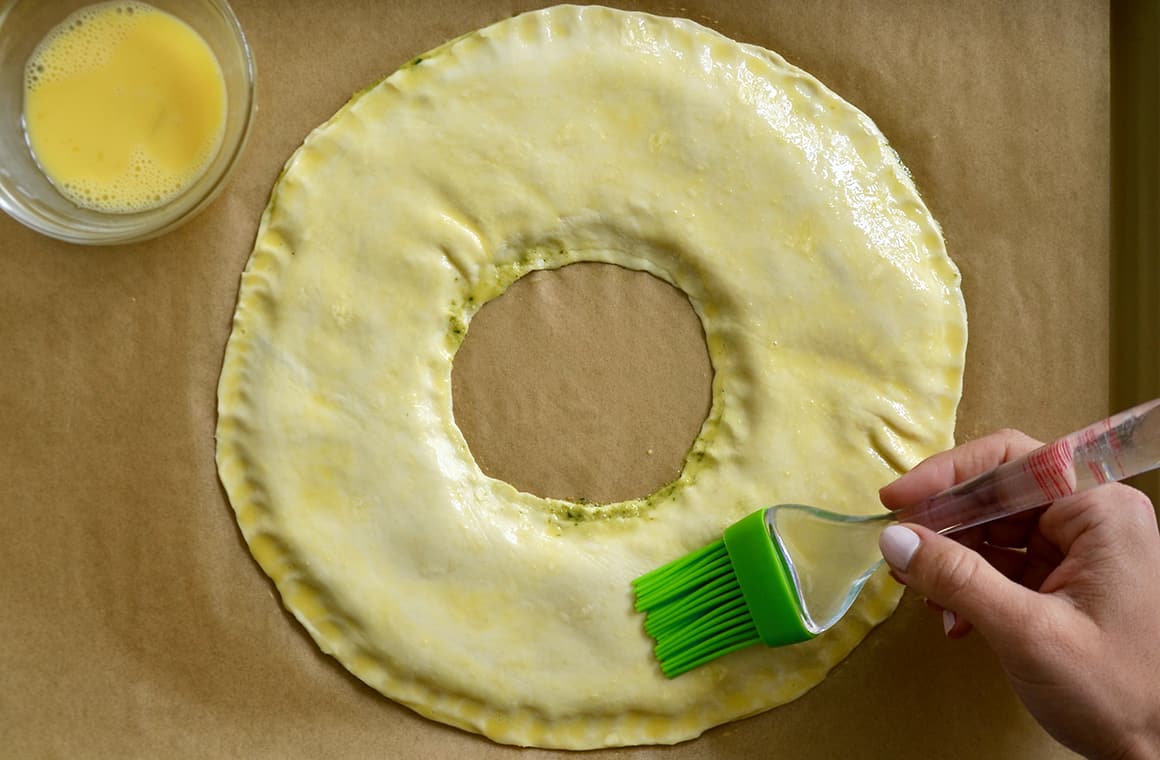 Top of the puff pastry being brushed with egg wash