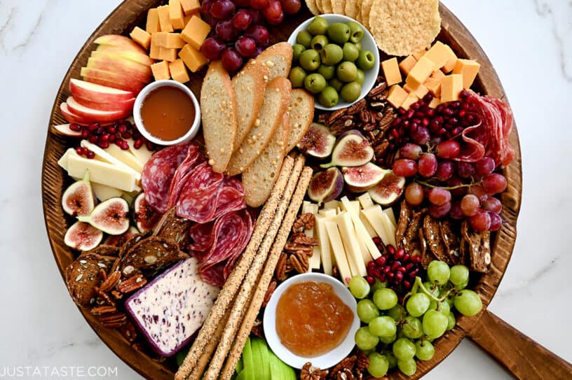 A charcuterie spread with meats, cheeses, olives, fruit and crackers