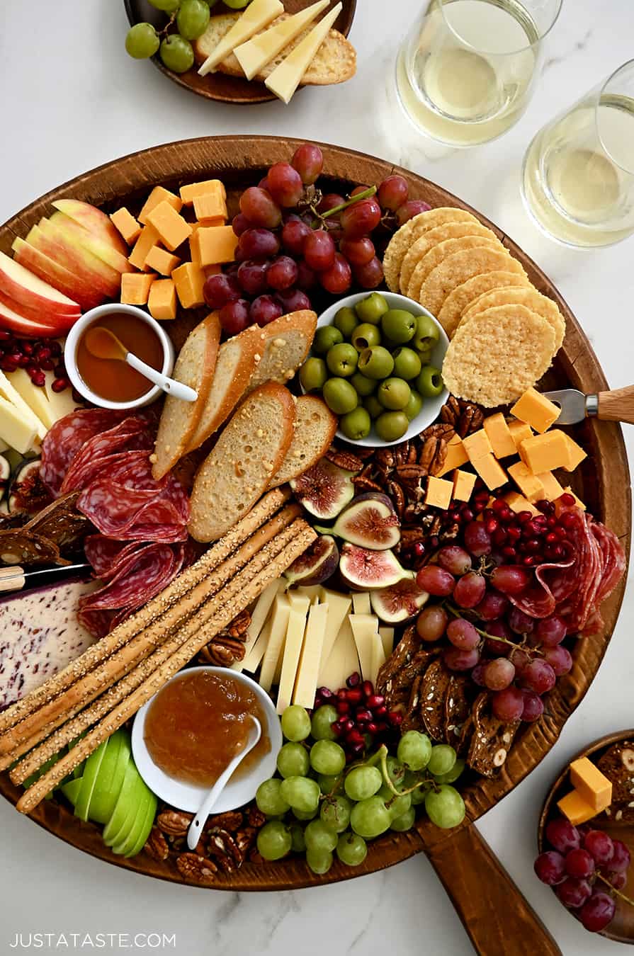 A fall charcuterie board topped with cheese, fruit, salami and olives