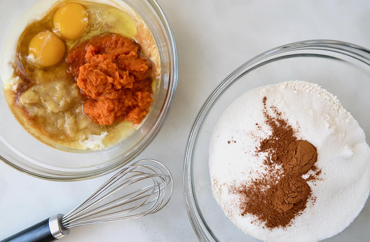 Two bowls: one with pumpkin puree, eggs, mashed banana and buttermilk; the other with flour, brown sugar and pumpkin pie spice. 