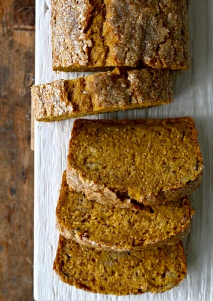 A loaf of pumpkin banana bread cut into thick slices.